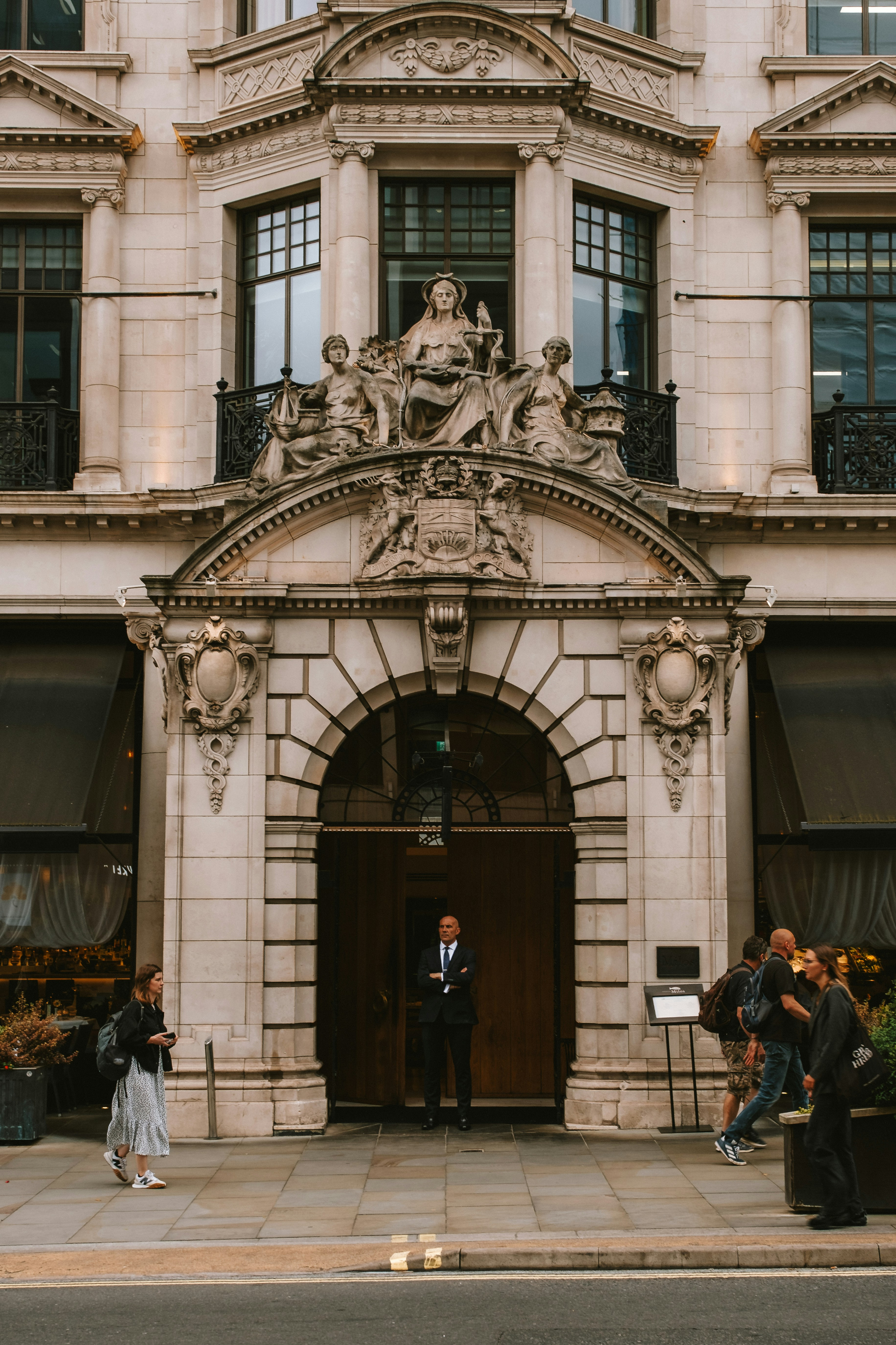 Photo of rows of books in a library with marble busts.